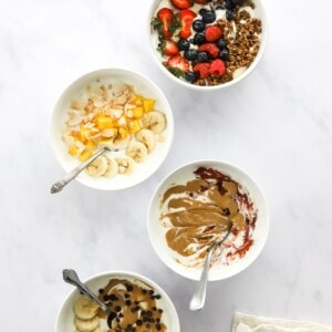 Overhead view of 4 different varieties of yogurt bowls.