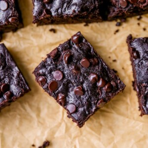 Overhead photo of a zucchini brownie on a sheet of parchment paper.