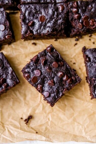 Overhead photo of a zucchini brownie on a sheet of parchment paper.