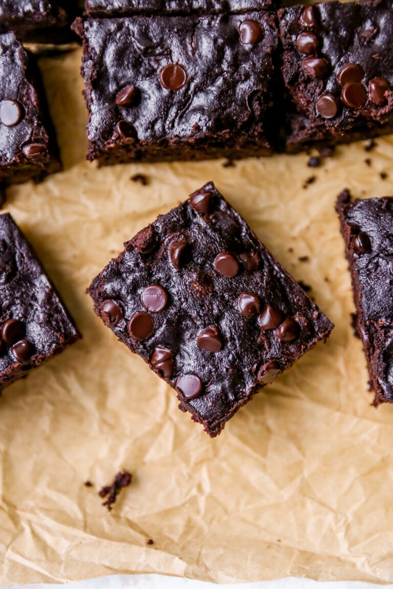 Overhead photo of a zucchini brownie on a sheet of parchment paper.