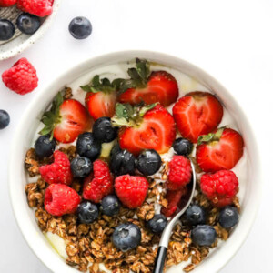 Yogurt bowl topped with granola, berries and honey.