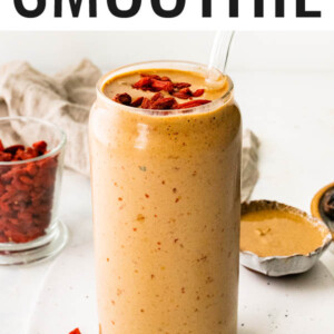 Glass full of a Butterfinger smoothie, topped with goji berries.