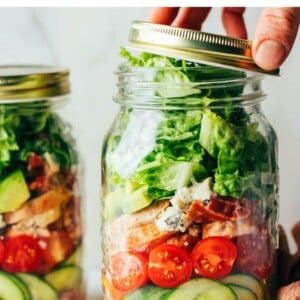 Mason jar filled with a chicken avocado club salad for meal prep.