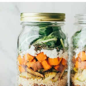 Mason jar layered with ingredients to make a meal prep kale sweet potato lentil salad.
