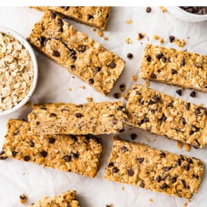 Rectangular peanut butter protein bars spread across a sheet of parchment paper.