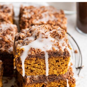 Stack of two slices of pumpkin coffee cake drizzled with icing.