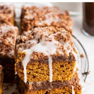 Stack of two slices of pumpkin coffee cake drizzled with icing.