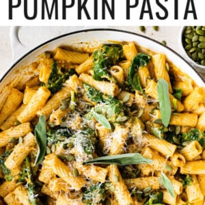 Pumpkin pasta in a pot topped with fresh sage, cheese and pepitas.