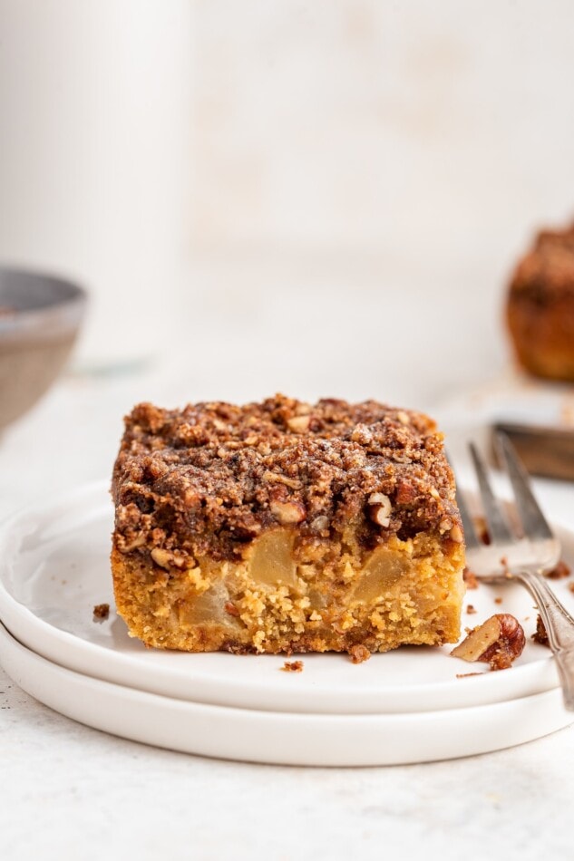 Slice of apple cake on a plate with a fork.