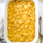 A serving dish containing baked cauliflower mac and cheese.