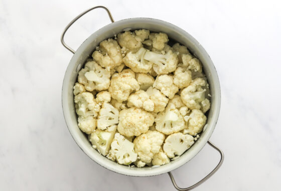 Cauliflower florets in a pot with water.
