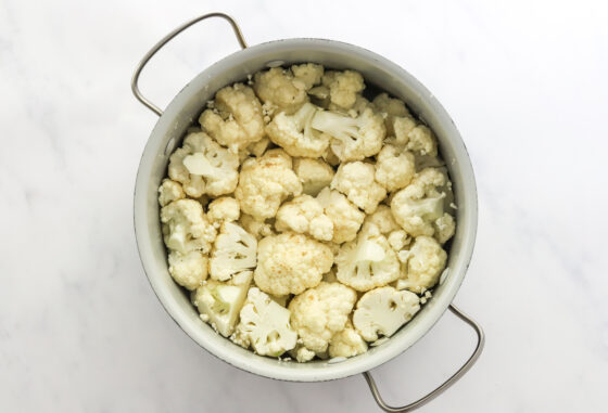 Cauliflower florets in a pot with water.