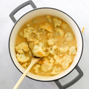 Cauliflower and cheese sauce mixed together in pot.