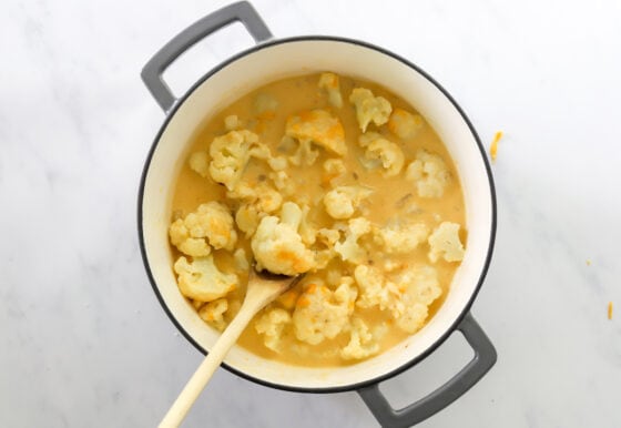 Cauliflower and cheese sauce mixed together in pot.
