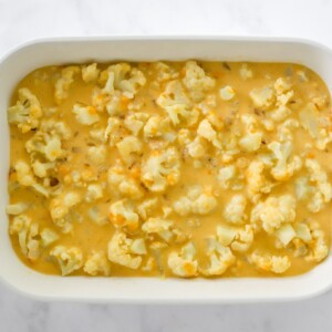 Cauliflower and cheese sauce spread in baking dish.
