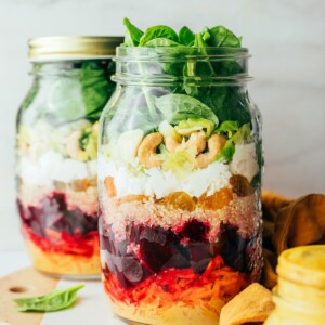 Two jars containing beet power salad. The front jar does not have a lid.