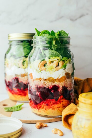 Two jars containing beet power salad. The front jar does not have a lid.