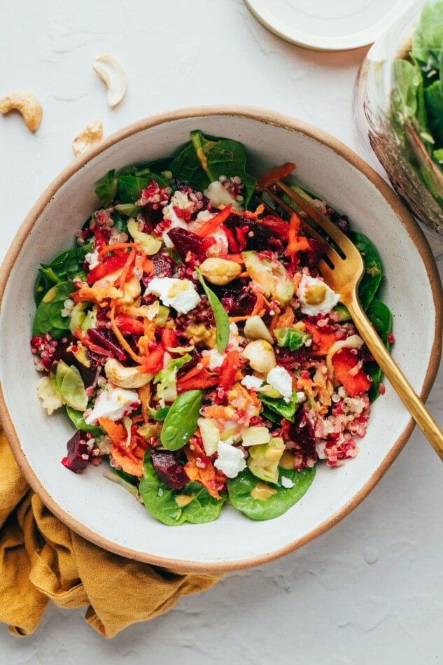 Beet power salad served in a bowl with a spoon.