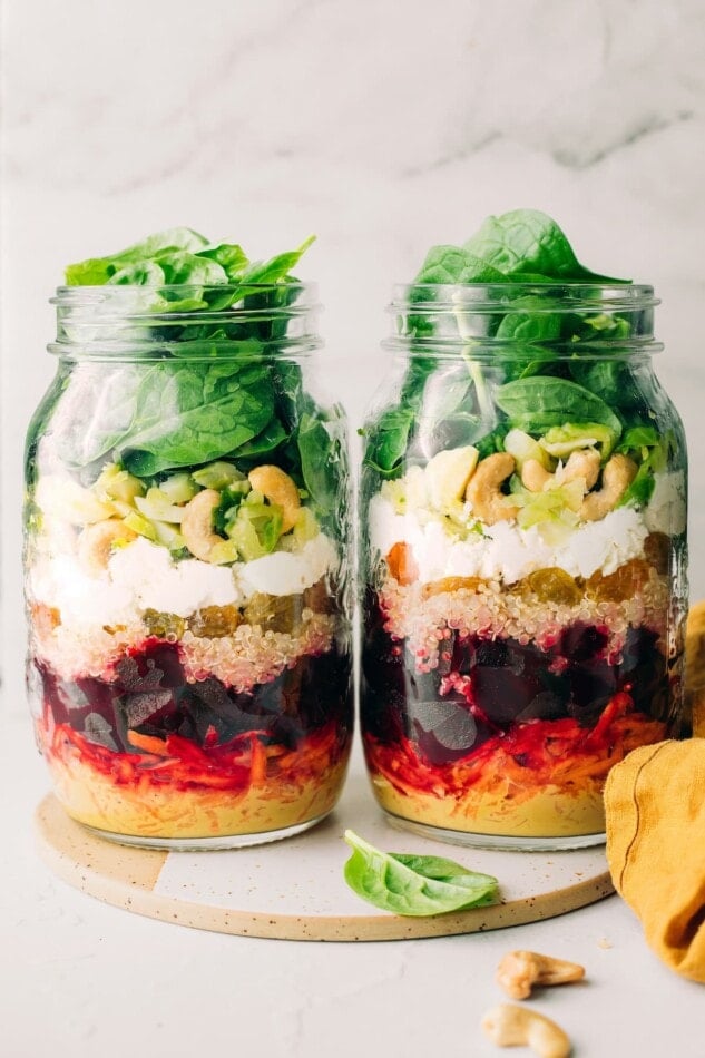 Two jars side by side containing beet power salad ingredients. The jars do not have lids.