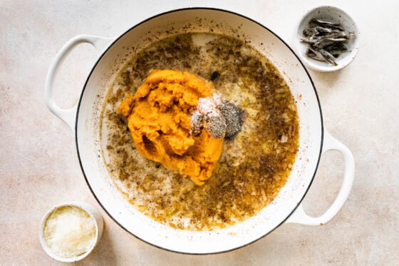 Adding pumpkin and spices to brown butter in pot.