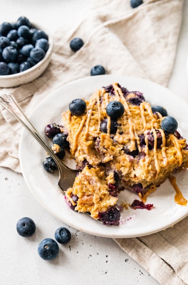 A plate of protein baked oatmeal on a plate. A fork has removed a bite.