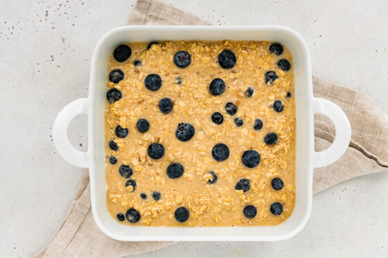 Oatmeal mixture added to prepared baking dish and topped with extra blueberries.