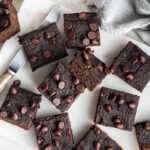 Overhead view of pumpkin brownie squares scattered around a cutting board.