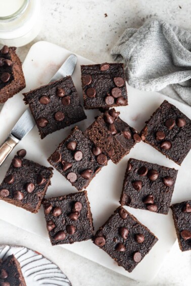 Overhead view of pumpkin brownie squares scattered around a cutting board.