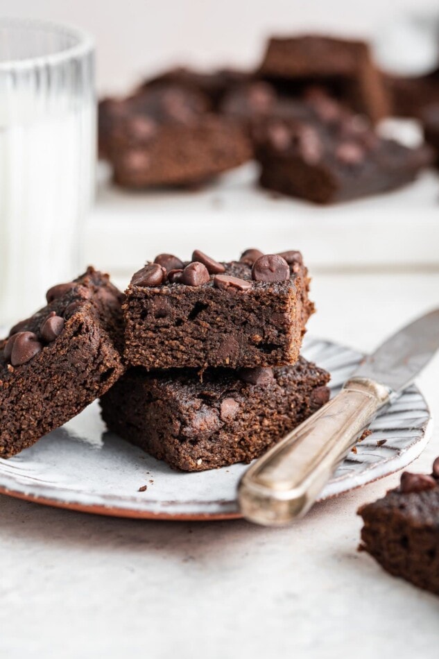 Three pumpkin brownies on a plate with a knife.