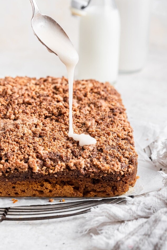 Drizzling icing on top of the pumpkin coffee cake square.