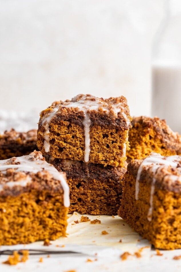 Squares of pumpkin coffee cake scattered around and on top of each other.
