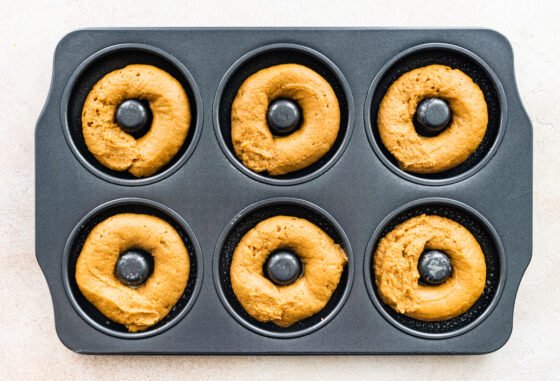 Donut batter piped into 6 donut pan cavities.