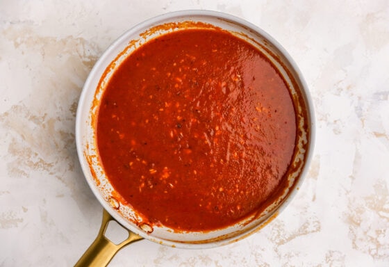 Chipotle peppers, adobo sauce, tomato sauce, oregano, chili powder, cumin, broth, salt and pepper in a sauce pan.