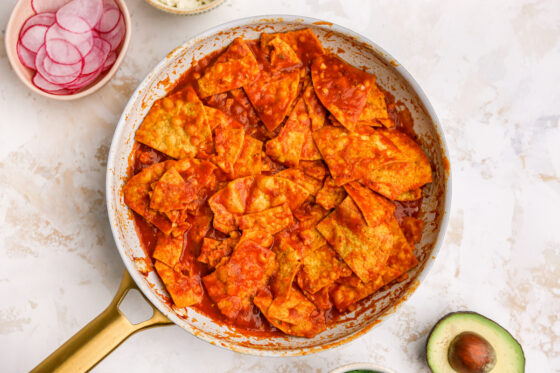 Tortilla chips cooked into sauce in pan.