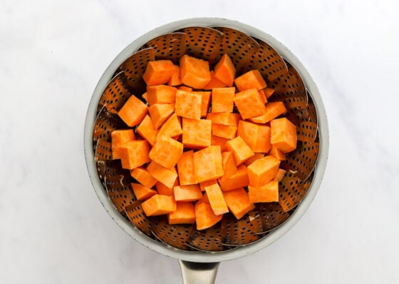 Sweet potato chunks in a steamer basket.