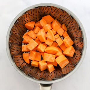 Sweet potato chunks in a steamer basket.