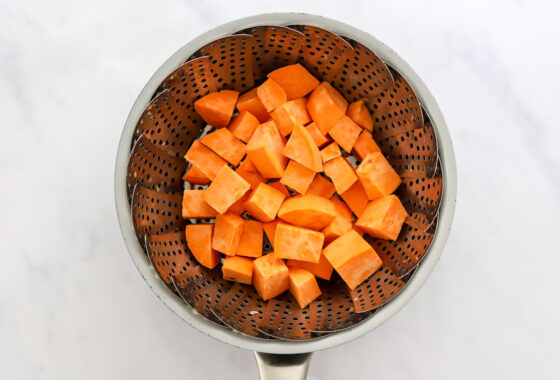 Sweet potato chunks in a steamer basket.