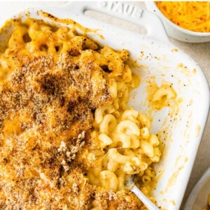 A baking dish containing healthy baked mac and cheese, some portions have been removed.