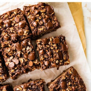 Baked oatmeal cut into 9 portions on a sheet of parchment paper.