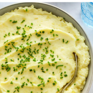 Close up of healthy mashed potatoes in a bowl topped with chives.