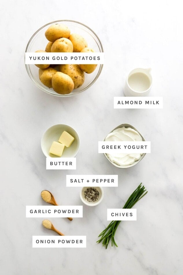 Ingredients measured out to make Healthy Mashed Potatoes: yukon gold potatoes almond milk, Greek yogurt, butter, salt, pepper, garlic powder, onion powder and chives.