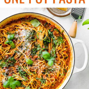 A pot containing one pot spaghetti topped with fresh basil and grated parmesan.