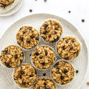 Overhead view of 8 oatmeal cups wrapped in paper liners organized on a plate.