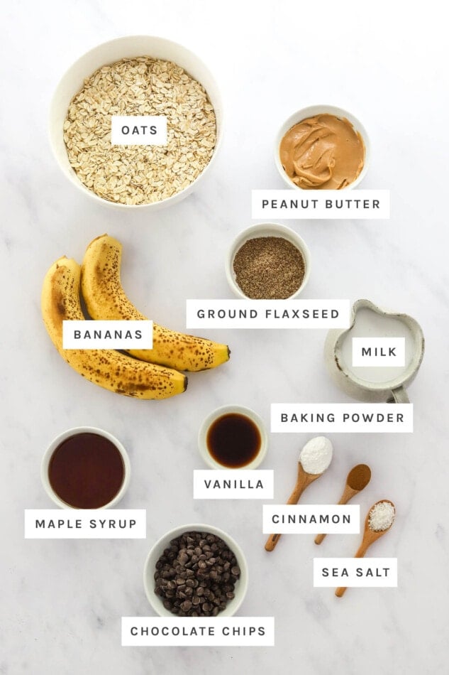 Ingredients measured out to make Peanut Butter Banana Oatmeal Cups: oats, peanut butter, ground flaxseed, bananas, milk, baking powder, vanilla, cinnamon, sea salt, maple syrup and chocolate chips.