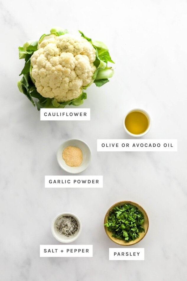 Ingredients measured out to make roasted cauliflower: cauliflower, olive/avocado oil, garlic powder, salt, pepper and parsley.