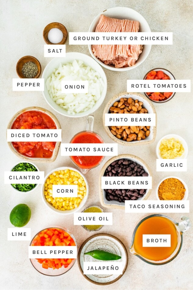 Ingredients measured out to make taco soup: ground turkey, salt pepper, onion, rotel tomatoes, pinto beans, diced tomatoes, tomato sauce, garlic, black beans, cilantro, corn, olive oil, taco seasoning, lime, bell pepper, jalapeño and broth.