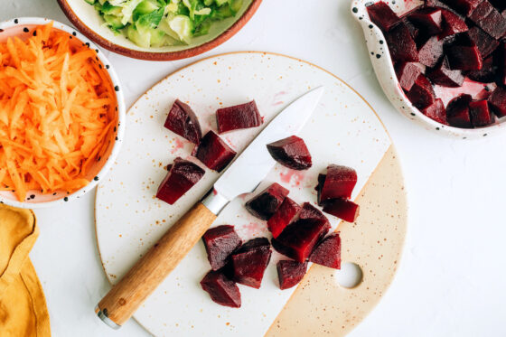 Chopping beets on a cutting board.