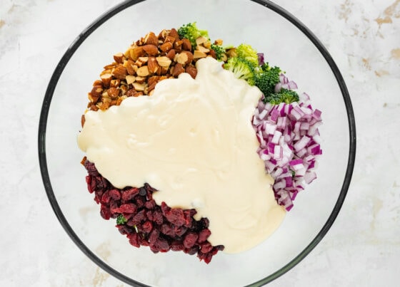 Dressing poured over the ingredients in a mixing bowl.