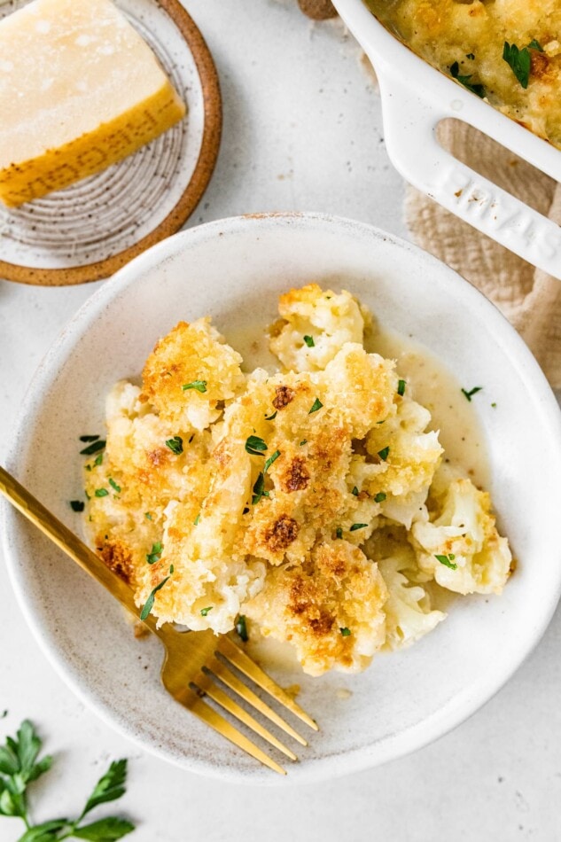 A serving of cauliflower gratin on a plate with a fork.