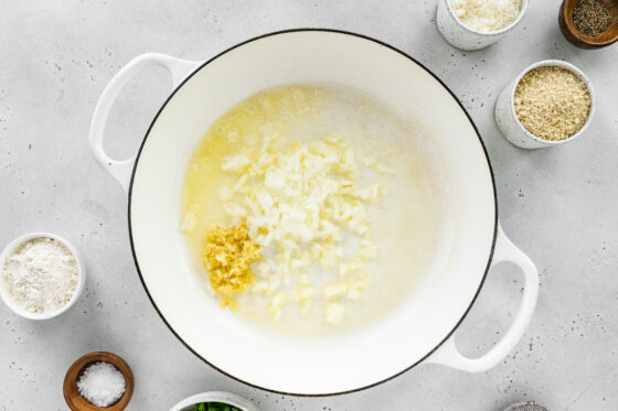 Onions and garlic cooking in butter in a pot.